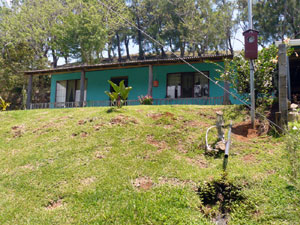 The house is located on a landscaped bank above the Lake Arenal highway.