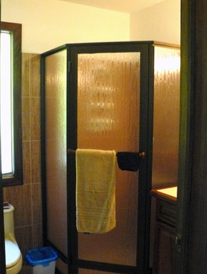 The bathrooms have large showers of three panelled obscure glass.